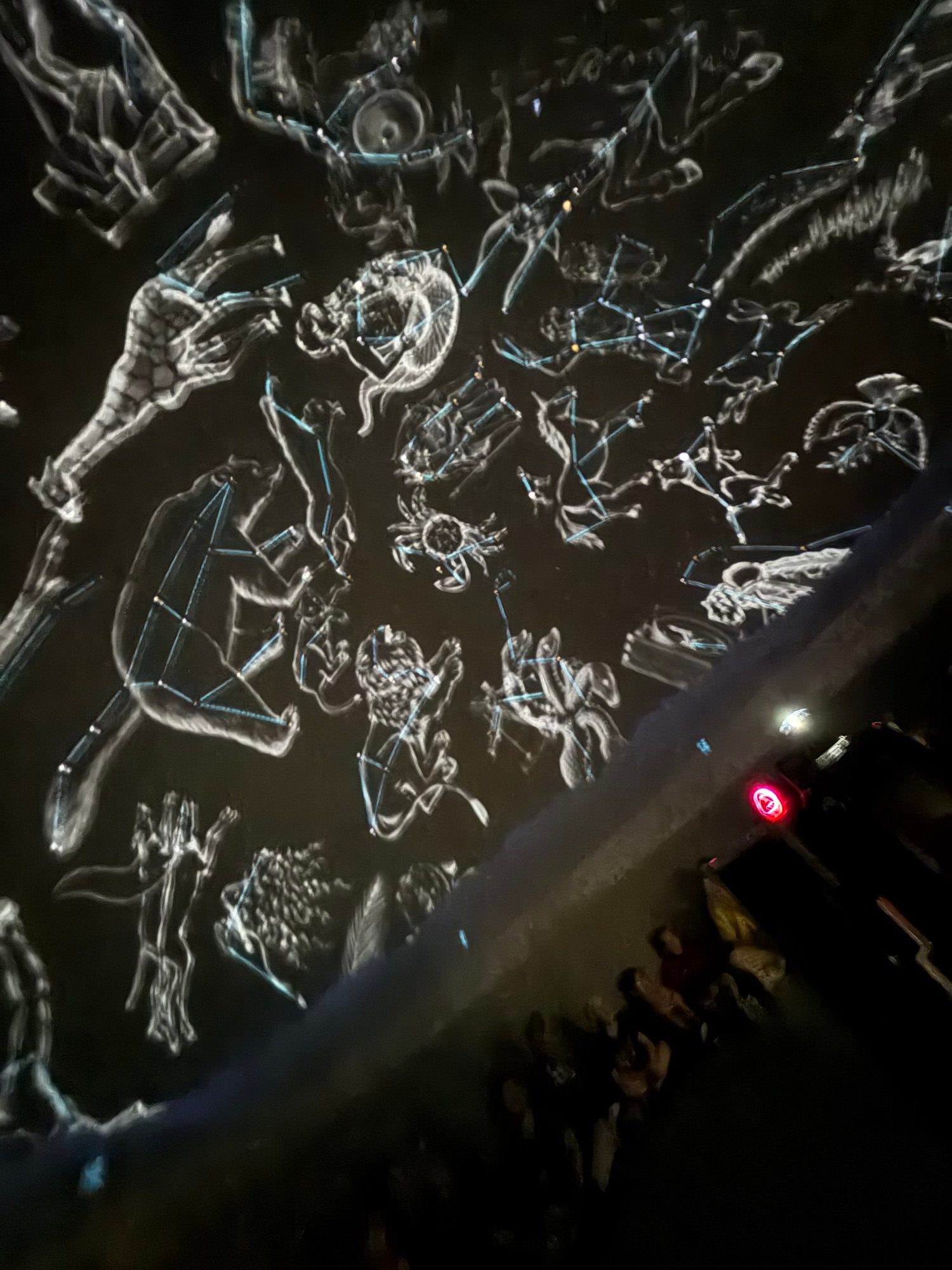 Glowing constellation figures projected across the dome sky