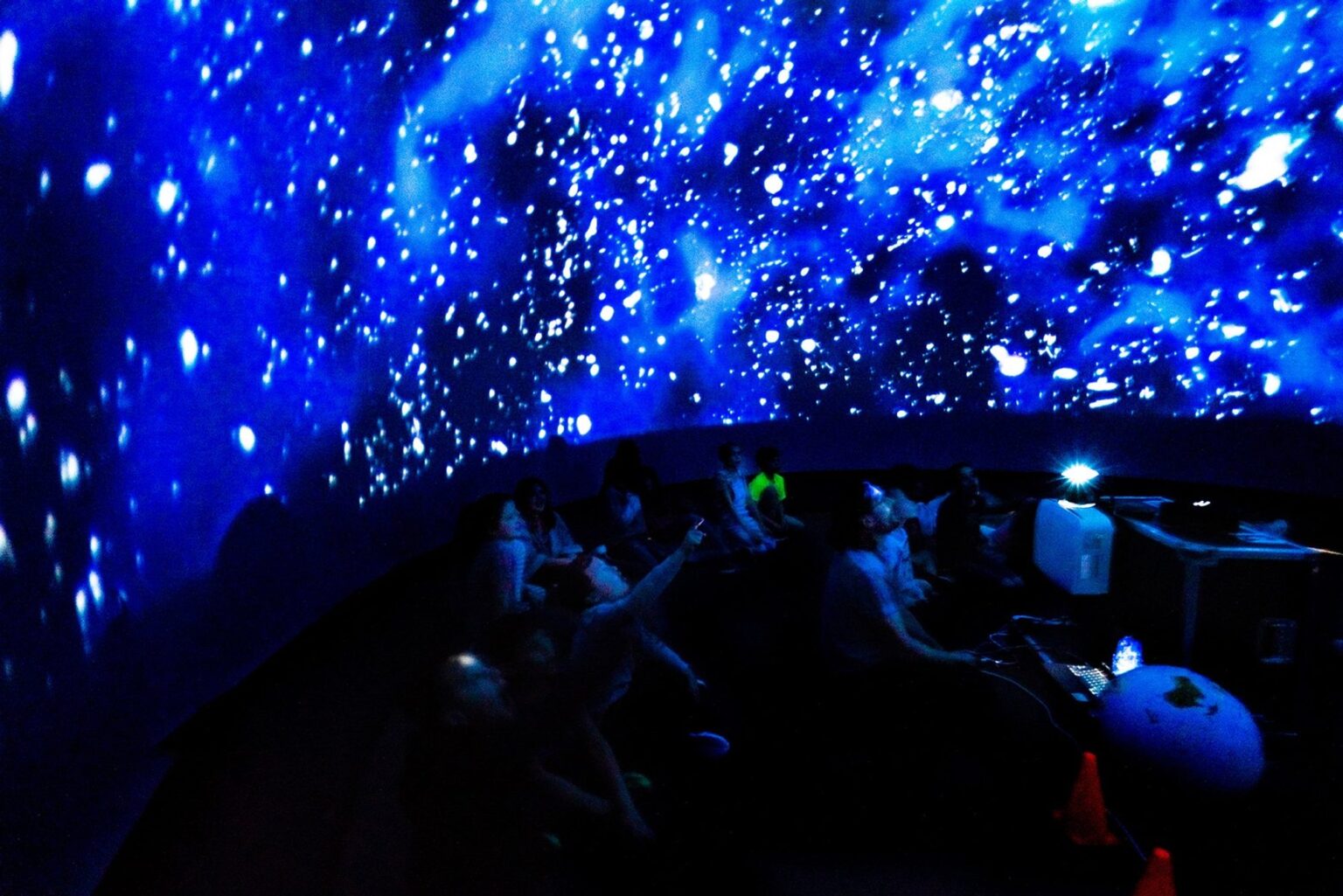 A full group of students seated inside the planetarium dome during a live session.