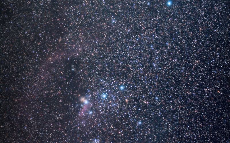 The constellation Orion in a dense field of stars.